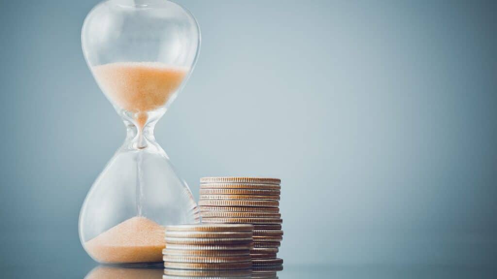 a hourglass and stacks of coins